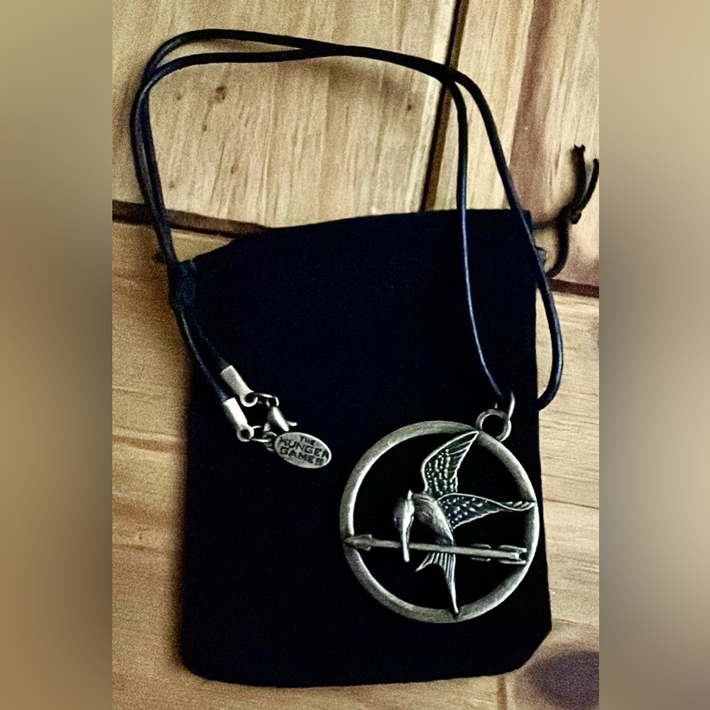The Hunger Games Mocking Jay pendant stamped hunger games and lions gate. 18”